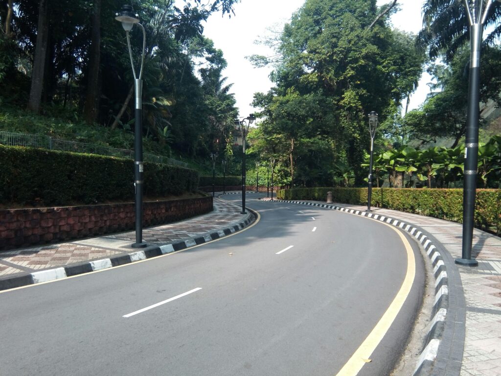 A scenic curved road lined with street lamps and greenery in Kuala Lumpur, Malaysia.